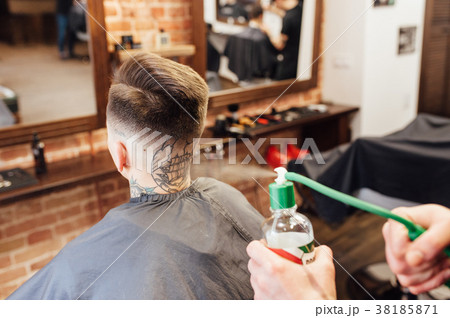 man getting trendy haircut at barber shop. man getting trendy haircut at barber shop. 38185871
