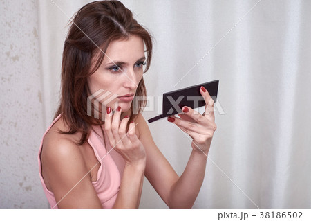 Beautiful woman doing herself make-up at home 38186502