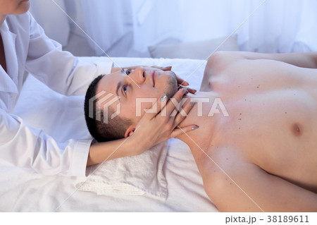 male masseuse makes a therapeutic massage male masseuse makes a therapeutic massage 38189611