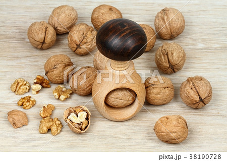 Wooden nutcracker in a mushroom shape and walnuts 38190728