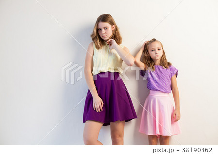 two girls in bright dresses on a white two girls in bright dresses on a white 38190862