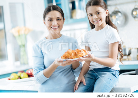 Smiling girl and her mother holding a plate with 38192726