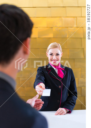 Hotel receptionist check in man giving key card Hotel receptionist check in man giving key card 38192727