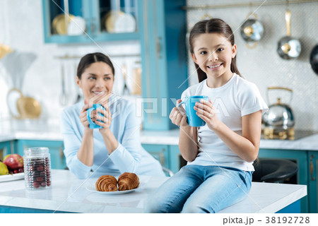 Alert daughter having tea with her mummy 38192728
