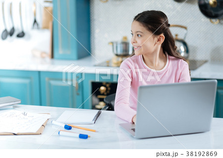 Cheerful young girl working on her laptop Cheerful young girl working on her laptop 38192869