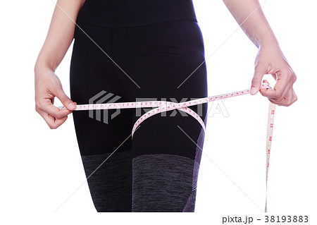 close up woman is measuring her thigh with measure tape isolated 38193883