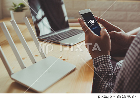 wifi  router and a man using smartphone 38194637