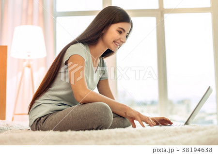 Cheerful teenage girl using laptop and smiling 38194638