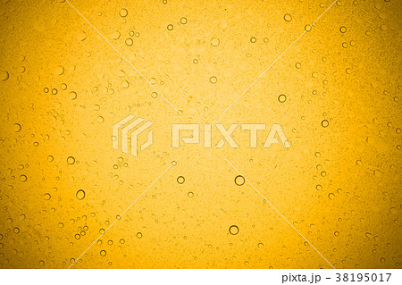Water drops on yellow glass. 38195017