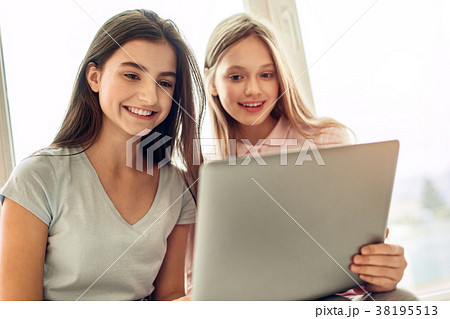 Smiling teenage girls watching videos together 38195513