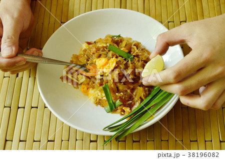 fork scooping stir fried rice noodles and squeeze  38196082