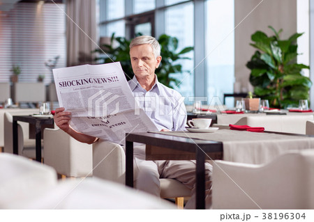 Earnest mature man reading newspaper Earnest mature man reading newspaper 38196304