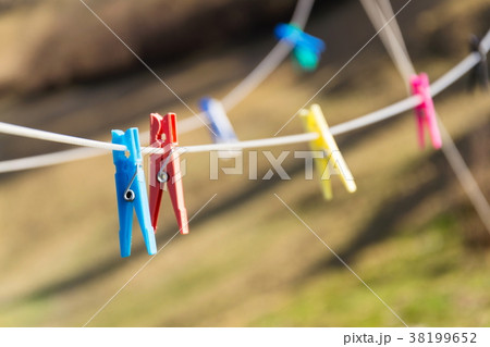 Colorful plastic clothes pegs on clothesline 38199652