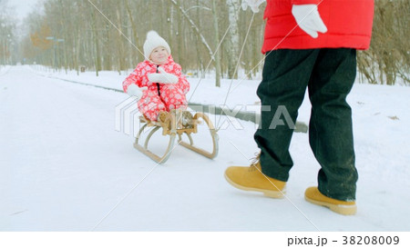 Happy little boy on the sledge in the winter park Happy little boy on the sledge in the winter park 38208009
