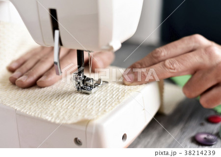 young man using a sewing machine young man using a sewing machine 38214239