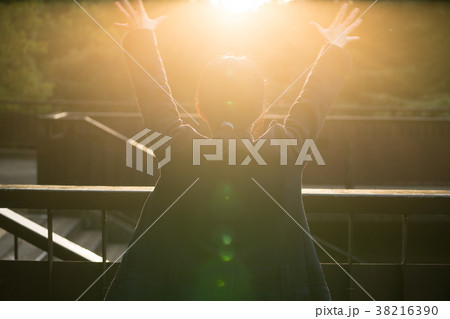 太陽に手をかざす女性 38216390