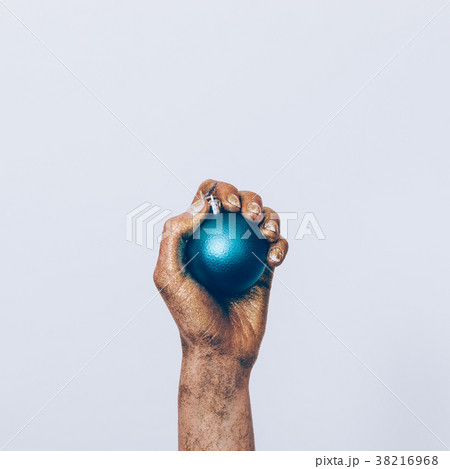 Close-up of a woman's hand in golden paint holding a blue Christ 38216968