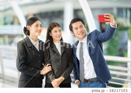 Businessman using smartphone selfie with partner. 38217103