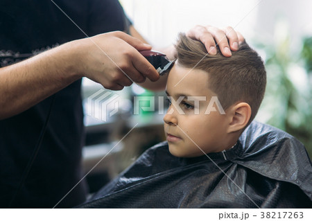 Professional hairdresser uses a hair clipper for 38217263