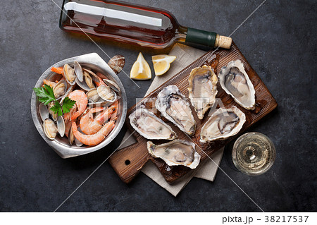 Fresh seafood and white wine on stone table 38217537