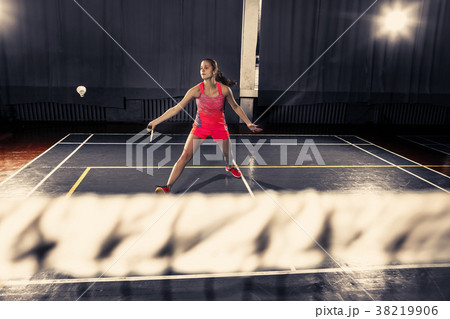 Young woman playing badminton at gym Young woman playing badminton at gym 38219906