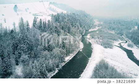 Aerial view of a forest, a small river and distant 38221699