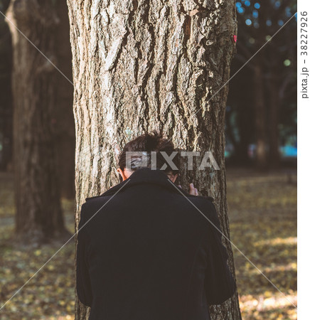 木にもたれて落ち込む女性 木にもたれて落ち込む女性 38227926