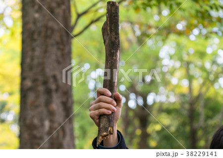 木の棒を振り上げる女性の写真素材