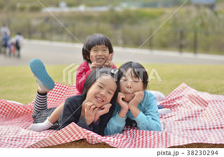 公園の芝生の上の三姉妹 38230294