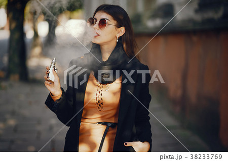 stylish girl smoking an e-cigarette stylish girl smoking an e-cigarette 38233769