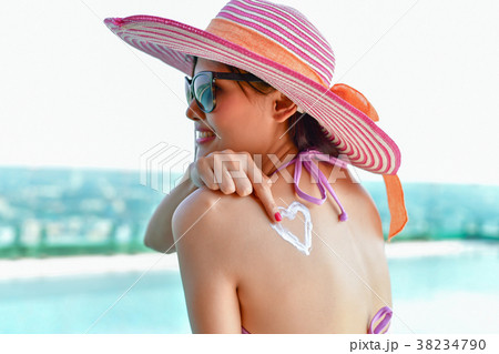 Swimsuit Concept. Beautiful girl in swimsuit is applying sunscre Swimsuit Concept. Beautiful girl in swimsuit is applying sunscre 38234790