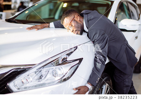 Handsome black man is hugging his new car and 38235223