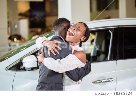 Couple collecting new car from salesman on lot Couple collecting new car from salesman on lot 38235224