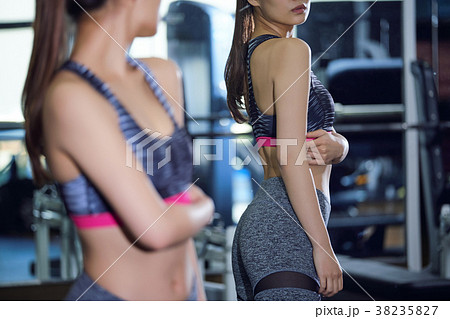 スポーツジム　ボディラインをチェックする女性 38235827