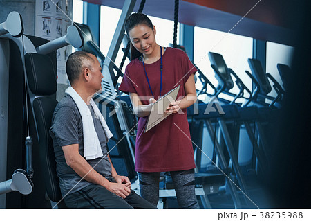 スポーツジム　マシントレーニング　トレーナーとシニア男性 38235988