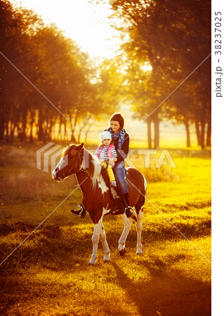 Mother and daughter riding a horse Mother and daughter riding a horse 38237025