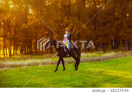 Mother and daughter riding a horse Mother and daughter riding a horse 38237034