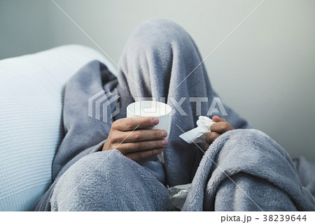 ill man warming up with a cup of hot milk 38239644