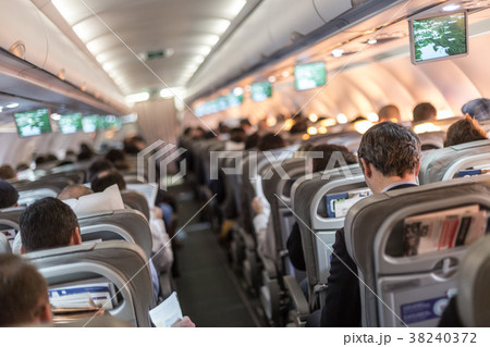 Interior of airplane with passengers on seats Interior of airplane with passengers on seats 38240372