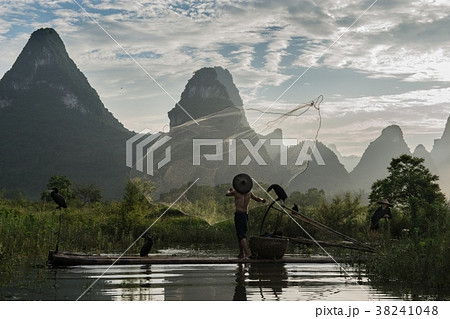 cormorant fisherman throwing netfish in sunset 38241048