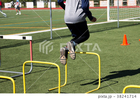 Athlete jumping over yellow hurdles 38241714