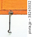Stained metal shutter hook installed on brown wood 38243032