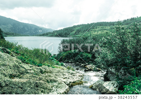 The peak view from the shore of a mountain lake.  38243557