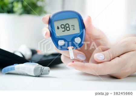 Woman checking blood sugar level by glucometer 38245660