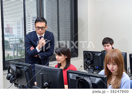 パソコン教室で勉強する大学生を教える教授 パソコン教室で勉強する大学生を教える教授 38247600
