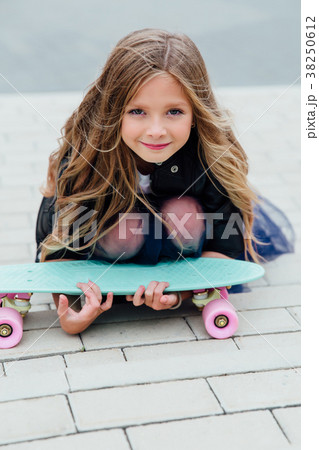 Fashion kid schoolgirlwith skateboard in the city Fashion kid schoolgirlwith skateboard in the city 38250612