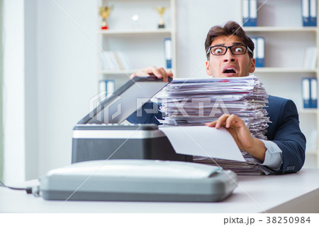 Businessman making copies in copying machine 38250984