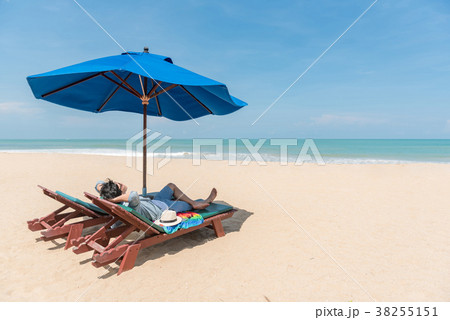 young Asain man traveler lying on beach bench 38255151