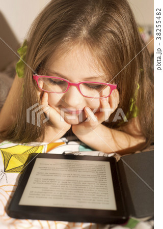 Little caucasian girl with a e-book in the bed Little caucasian girl with a e-book in the bed 38255482