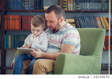 Image of happy father and young son sitting with 38256670